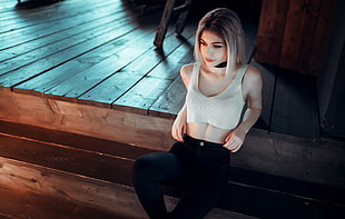 woman wearing white crop-top and black leggings sitting on stairs