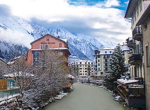 concrete buildings between river with mountain background, chamonix HD wallpaper