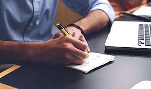 person writing on white printer paper