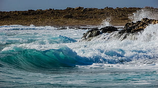 crashing waves on rocks during dayttime