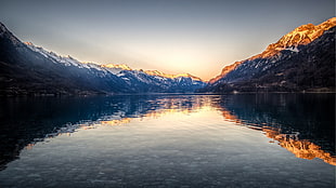 photo of lake surrounded by mountains during golden hour