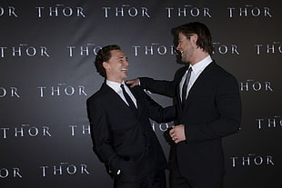 Thor Movie Actor standing beside another man in black suit movie premier