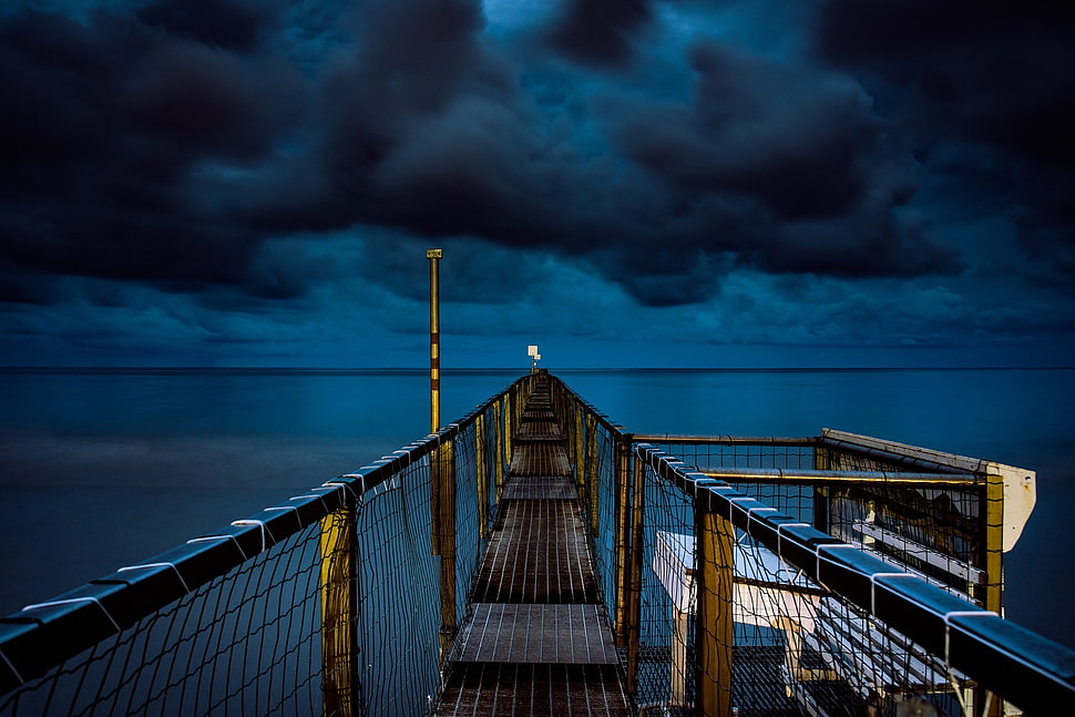 brown wooden and net bridge during dark cloud poster HD wallpaper