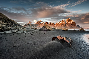 seashore with mountain backgrounds under cloudy sky photo