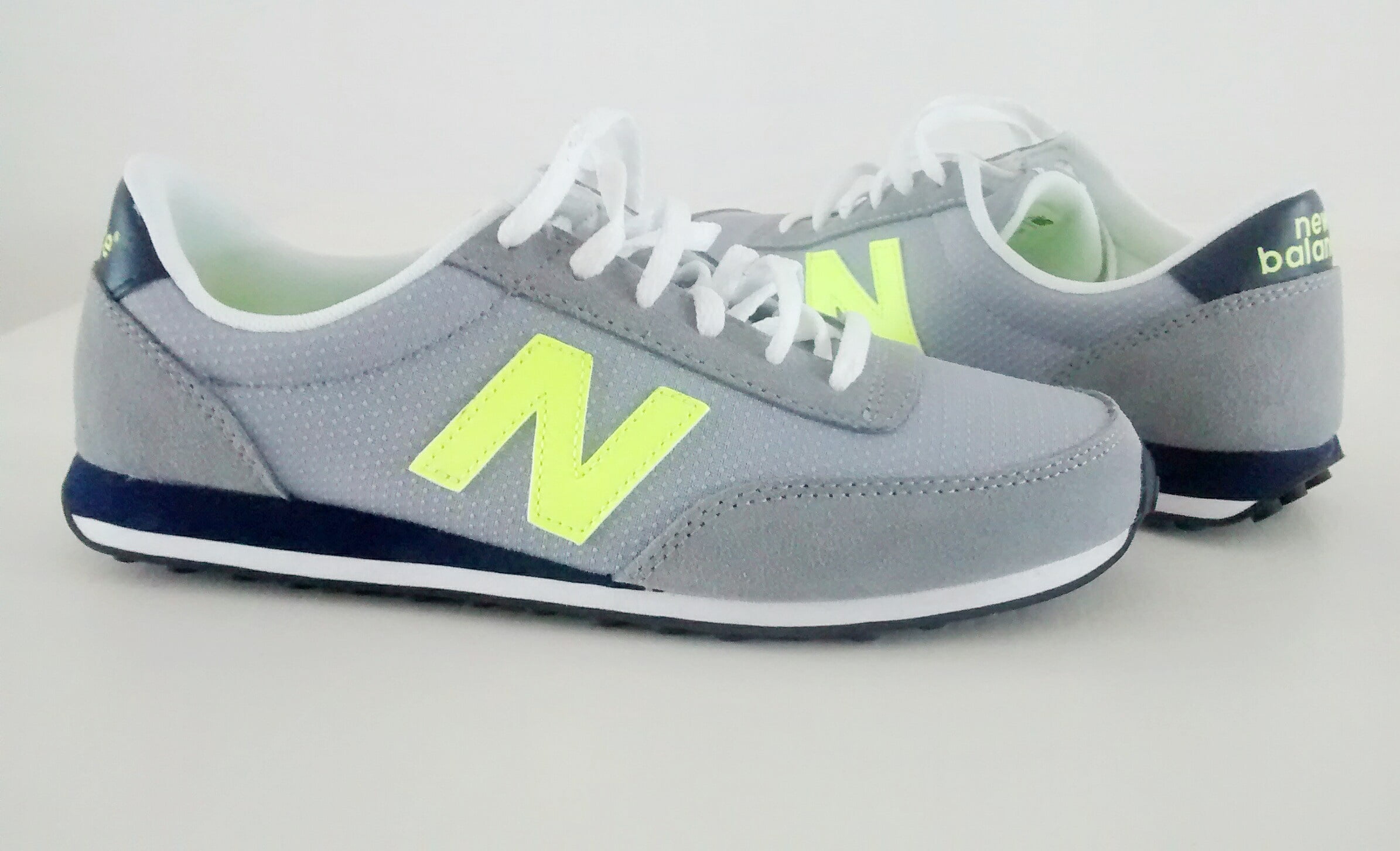 pair of gray-and-green New Balance running shoes