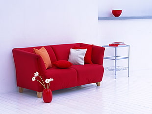 red couch with nude and white throwpillows