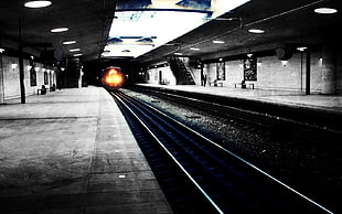 subway station with lights on and train approaching