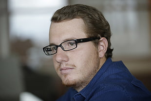 man in blue dress shirt wearing eyeglasses with black frame