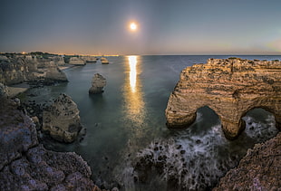 time lapse photography of waterfalls between rock formation during sunset, praia