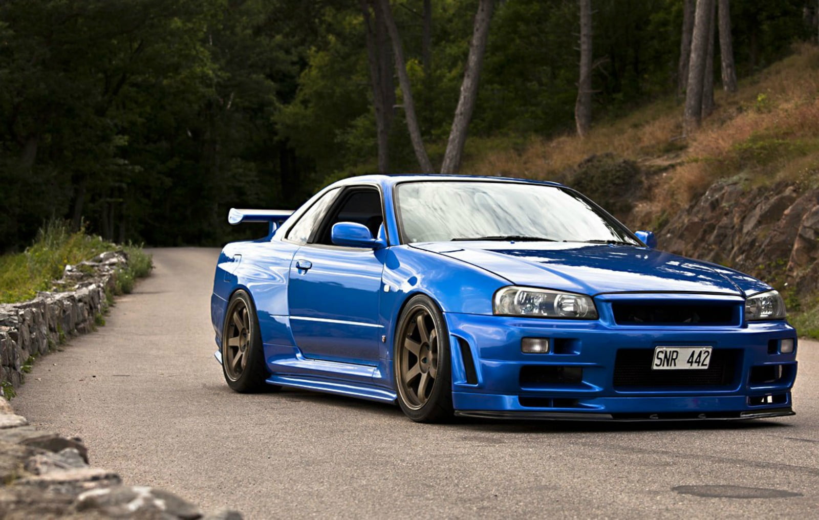 blue coupe on gray asphalt road