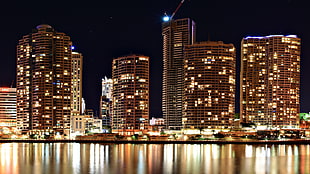 Cityscape near body of water by night photography