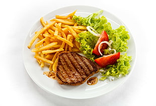 grilled meat, french fries and slice tomatoes on white plate