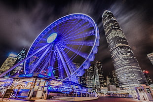 time lapse photography of ferris wheel near building during nighttime, hong kong