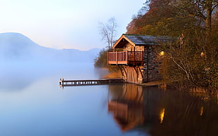 brown house beside lake during daytime HD wallpaper