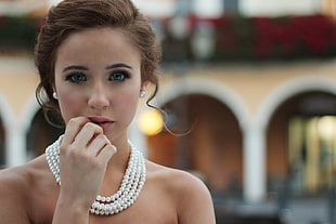 tilt shift lens photography of woman wearing white pearl earrings