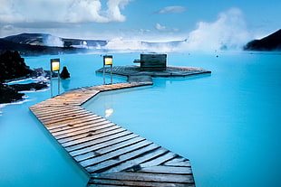 gray wooden dock surrounded by body of water, iceland
