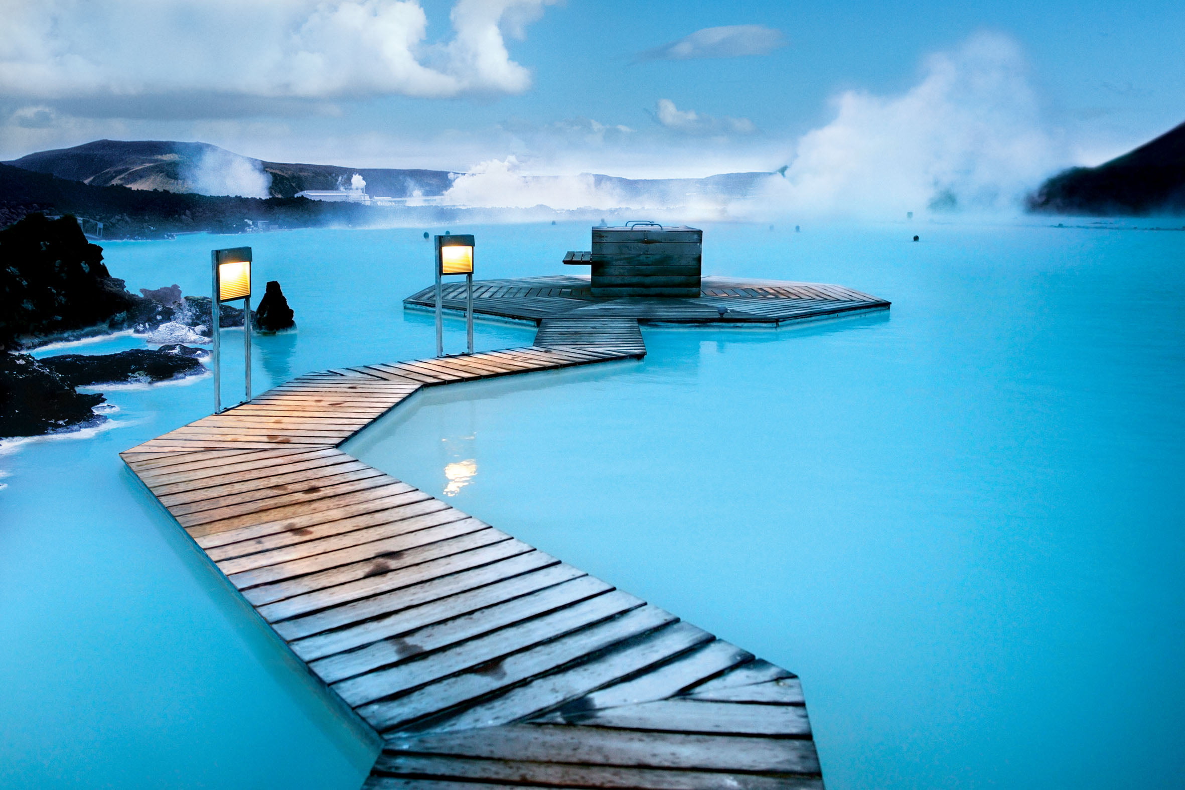 gray wooden dock surrounded by body of water, iceland