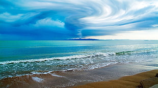 green body of water under cloudy sky