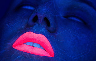 blue painted human's face with red lipstick