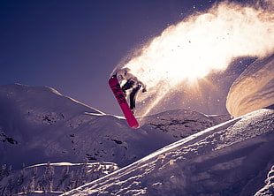 man wearing white hoodie snowboarding