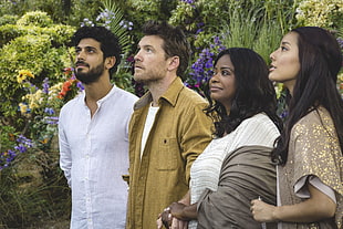 two men and two women looking up surrounded by flowers