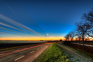 time lapse photo of road near bare trees during nighttime HD wallpaper