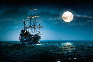 sailing boat under full moon during nighttime