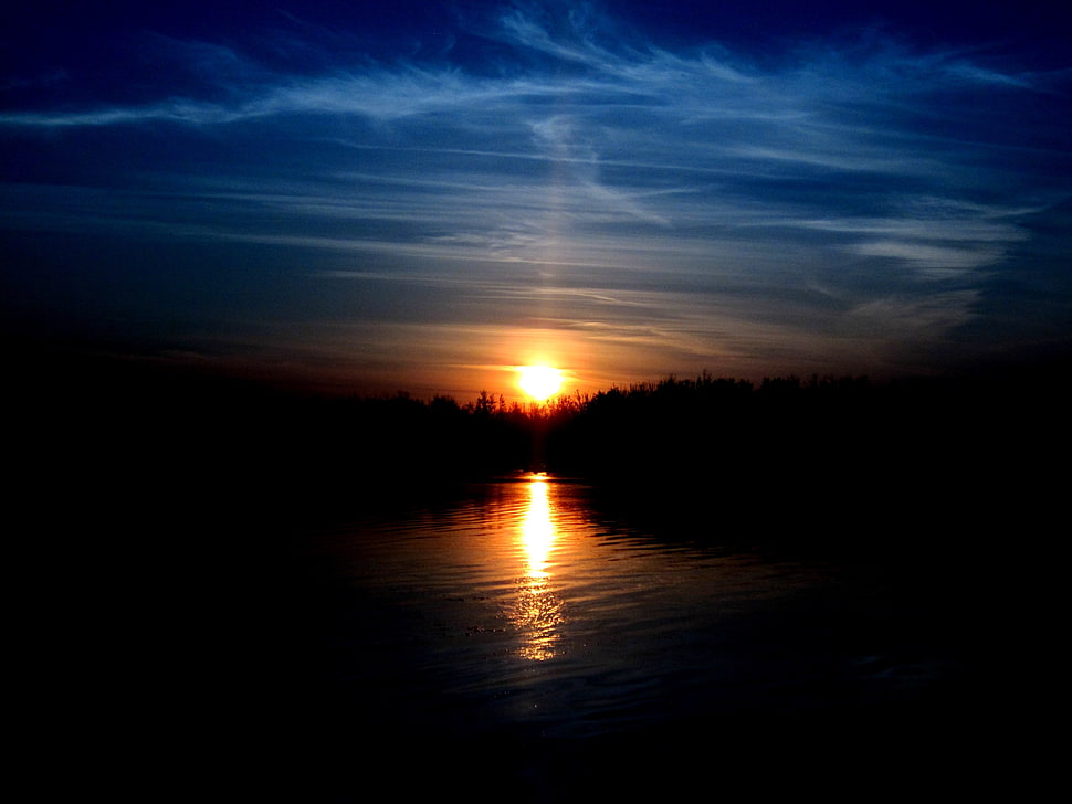 golden hour over trees and river showing reflection on water HD wallpaper