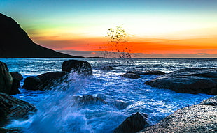 timelapse photo of ocean waves crashing at stones at sunset HD wallpaper