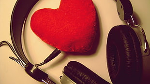 black and gray headphone with red heart shaped pillow