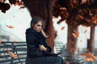 shallow focus photography of woman sitting on bench