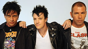three men wearing black jacket facing camera