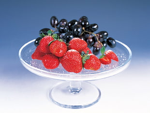 strawberry and grapes on clear glass holder