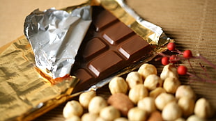 opened chocolate bar beside nuts