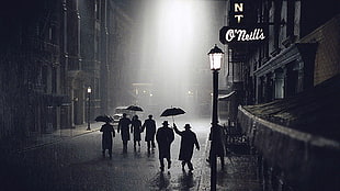 silhouette of people on street while raining