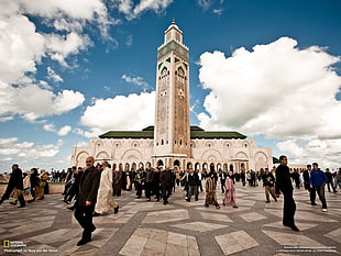 group of people walking beside mosque