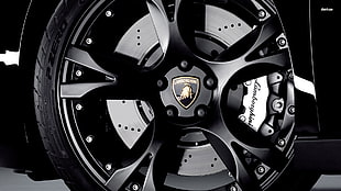 close up photo of black 10-spoke Lamborghini wheel with tire