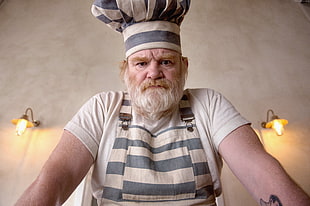 male chef in white top and white-and-gray striped apron
