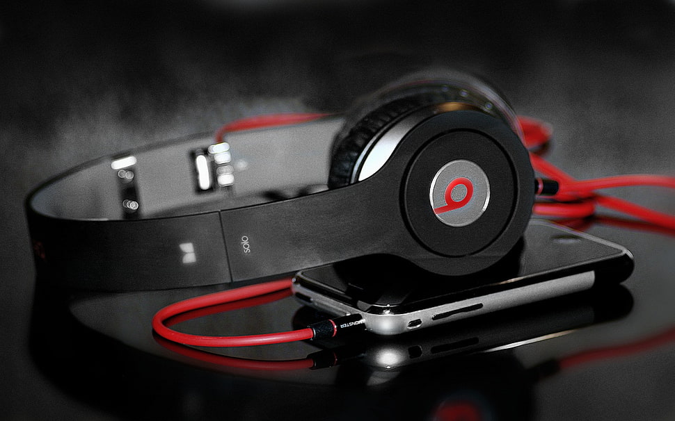 black Beats corded headphones plugged on iPhone HD wallpaper