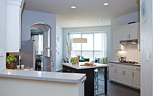 white wooden kitchen cupboards beside white and brown wooden dining set