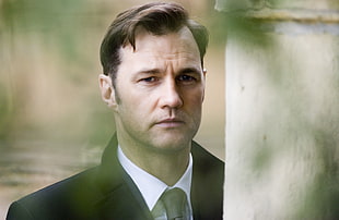 man wearing black formal coat