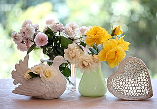 white, yellow, and pink floral bouquet on green ceramic vase