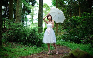 photography of woman wearing white spaghetti strap mini dress, holding an umbrella