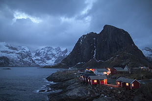 houses near body of water with mountains