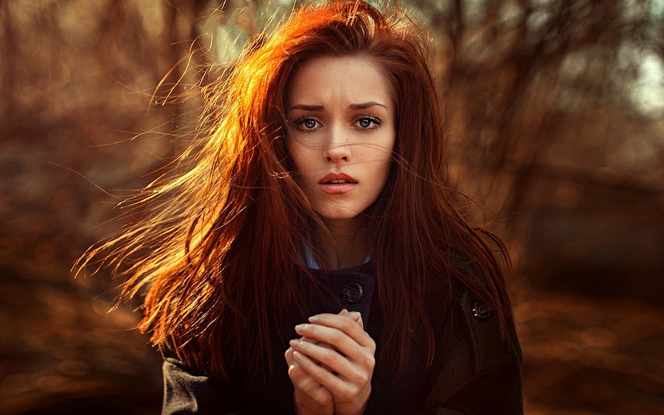 red haired woman in black double-breasted coat holding her hands in bokeh photography HD wallpaper