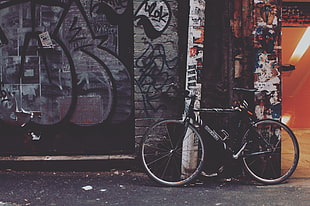 black bike parked on graffiti wall