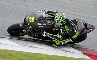 man in green and black motor suit riding sports bike