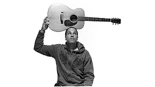 man wearing jacket holding acoustic guitar