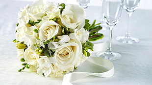 white bouquet of rose beside wine glass