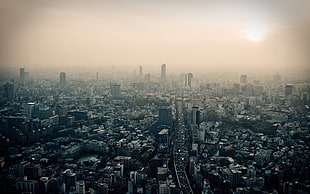 grayscale photo of a city with smog under sun